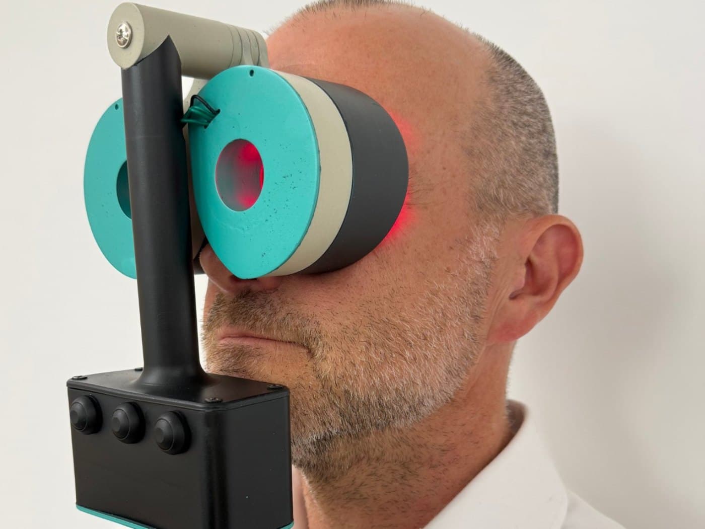 The Revolux photobiomodulation device in use, with red therapy light visible